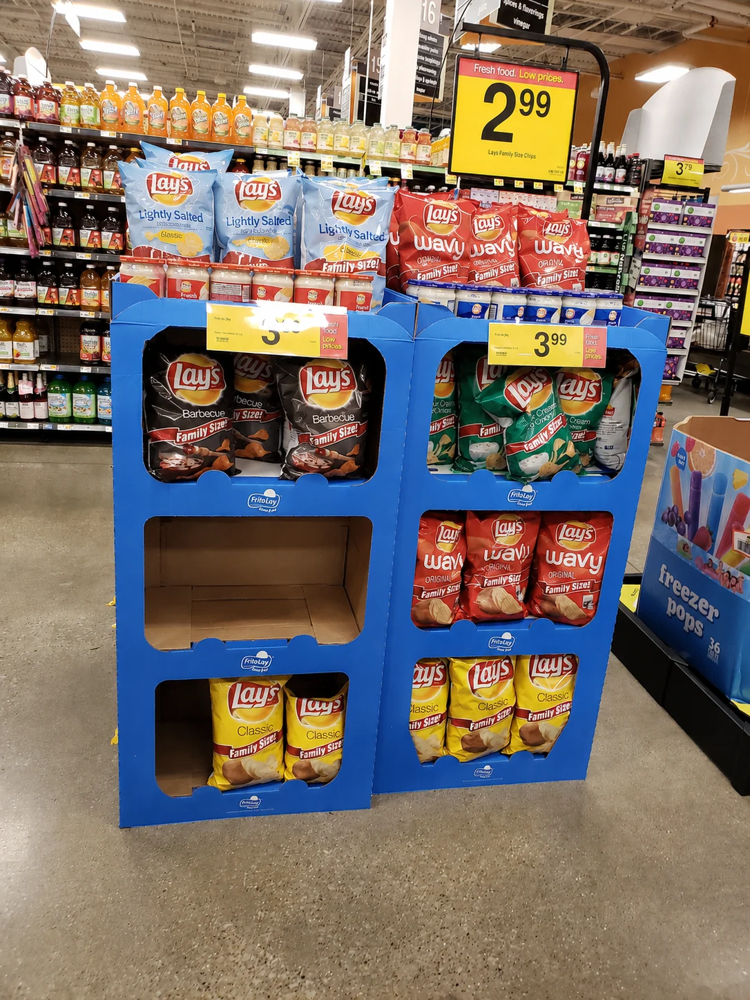 A cardboard promotional end-cap display with one of its six product compartments left completely empty.